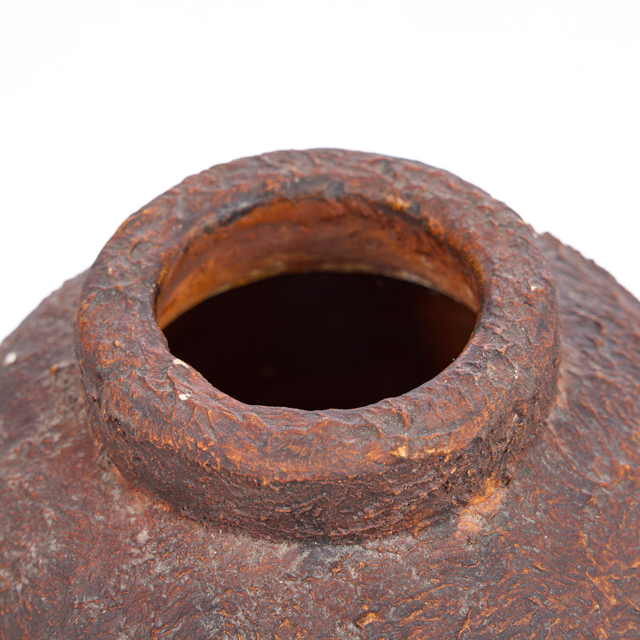 Close-up of a rusty terracotta vase on a white background