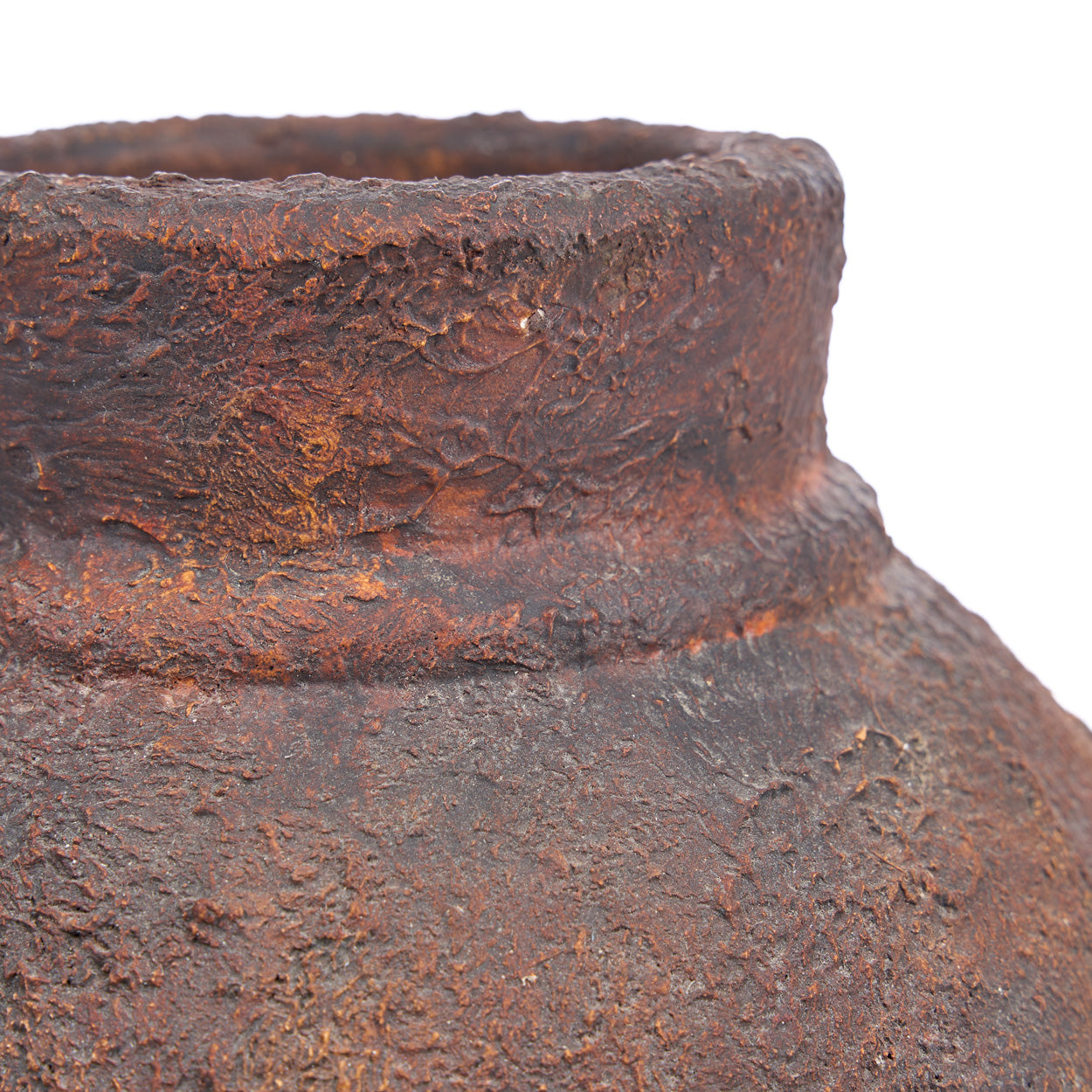 Close-up of a rusted terracotta vase on a white background