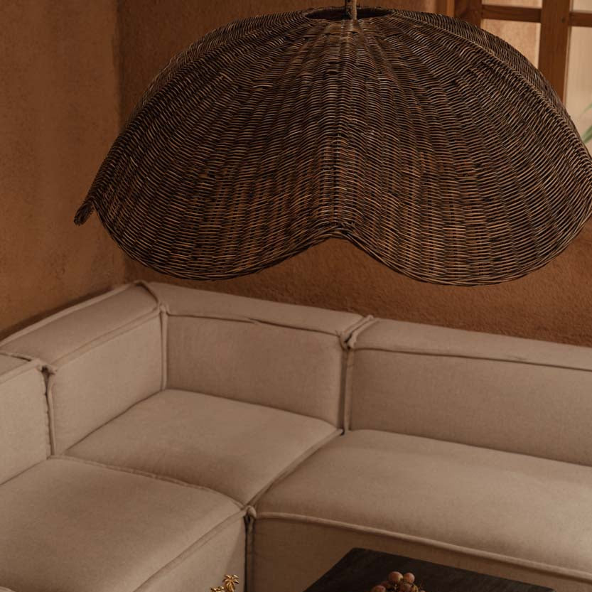 Beige sectional sofa with a dark coffee table and the Wave Pendant - dark walnut in a warm-toned room.