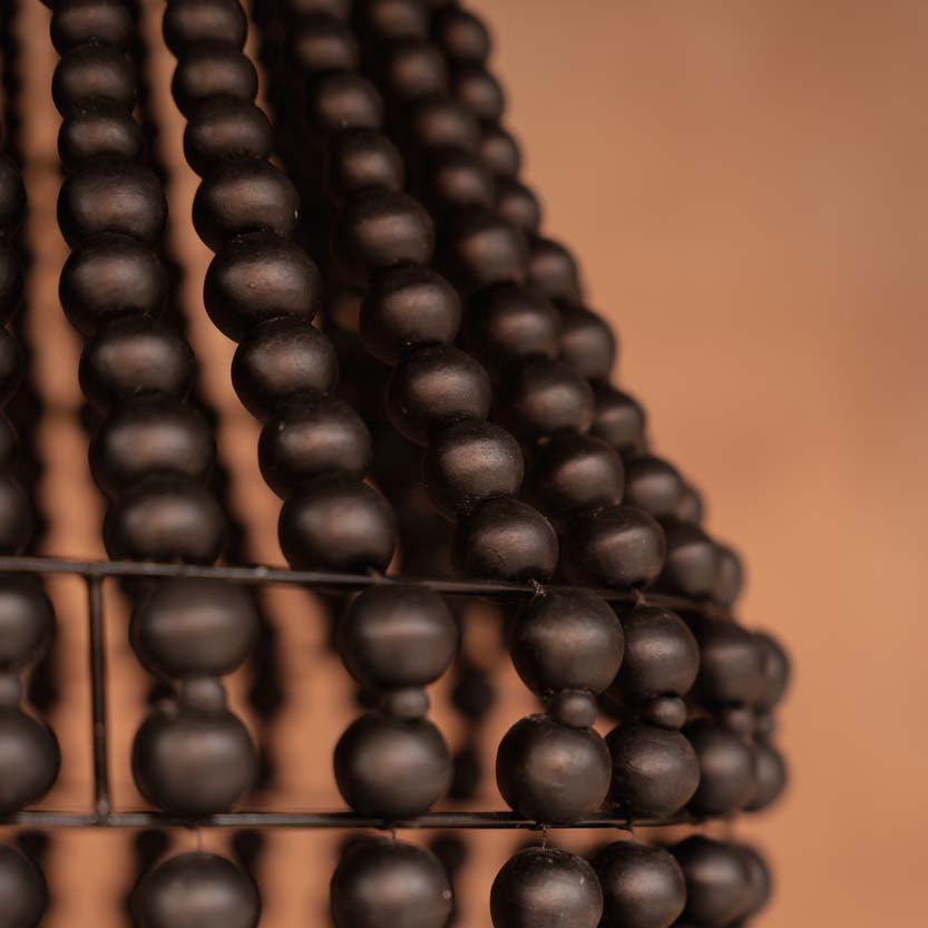 Close-up of dark wooden beads on chandelier on a brown background.