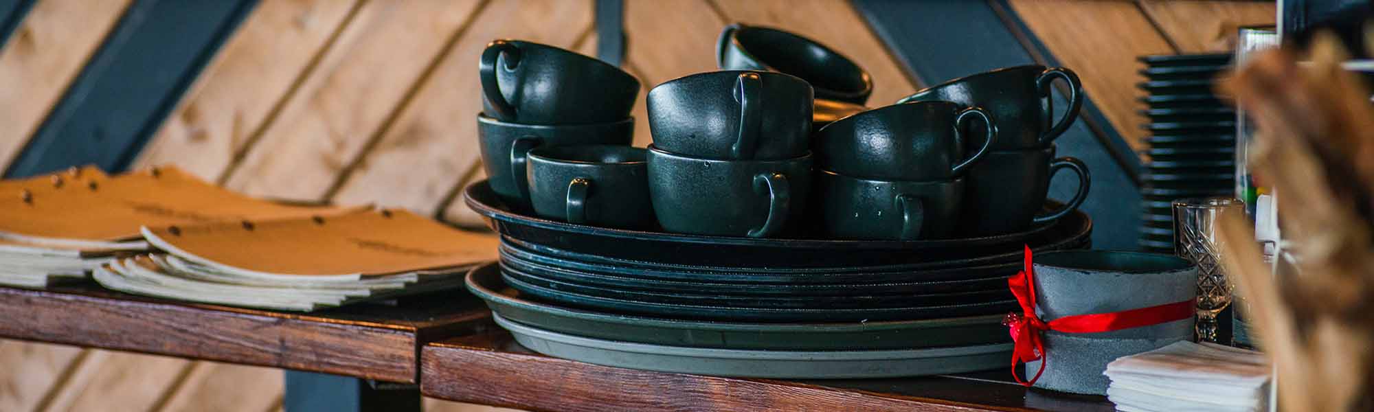 Handmade black ceramic trays and cups on the shelf
