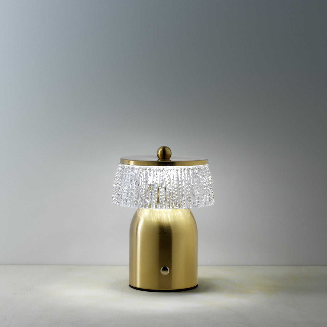 Gold table lamp with crystal detailing on a gray background
