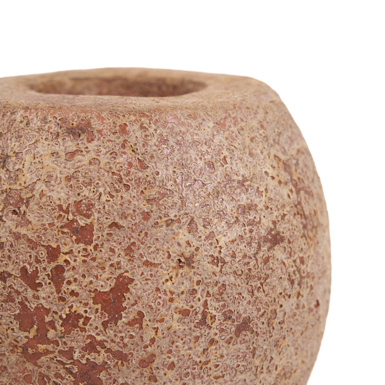 Close-up of a textured ceramic candle holder on a white background