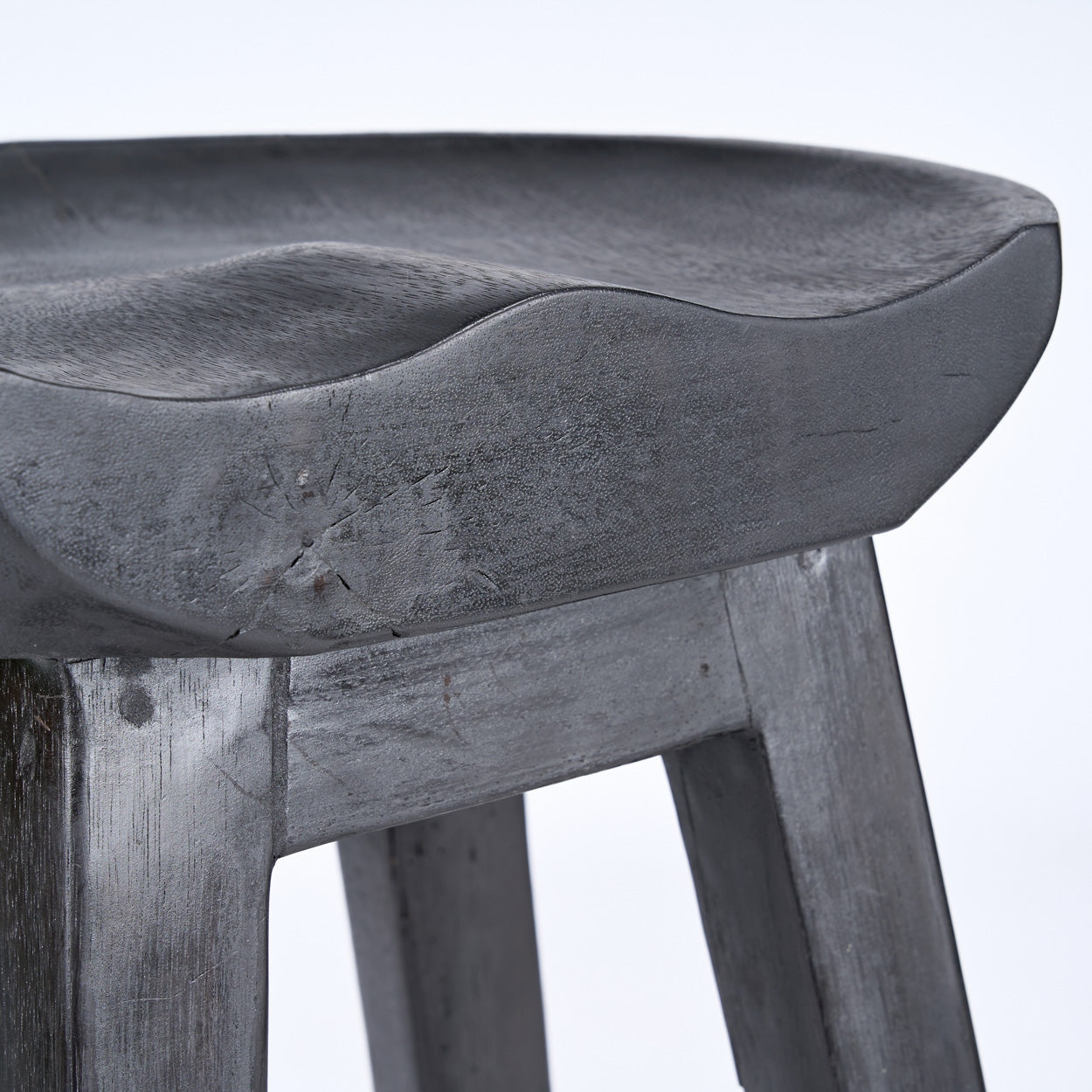 Close-up of a wooden bar stool with a black finish on a white background