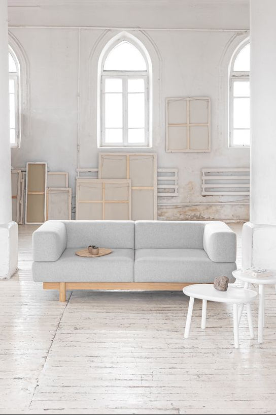 Modern living room with a gray ALCHEMIST sofa in a white, minimalist space.